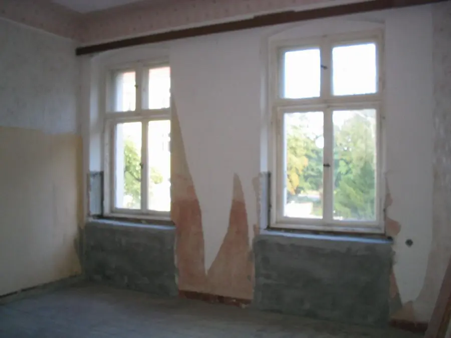 Altbauzimmer mit Feuchteschäden unter den Fensterbrüstungen