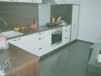 Fertig aufgebaute weiße Einbauküche mit Holzarbeitsplatte im Altbau