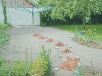 Wäschespinne im Garten mit markiertem Weg aus Rindenmulch