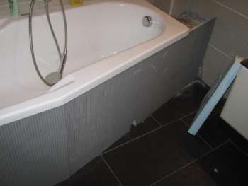 Badewanne mit zugeschnittenen Hartschaum-Bauplatten verkleidet