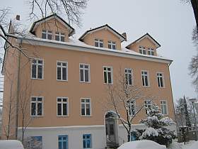 Sanierter Altbau mit drei Dachgauben im Winter, Dach und Garten verschneit