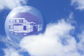 Haus in einer Seifenblase vor Wolkenhimmel