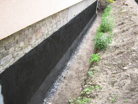 Vollflächig mit Bitumen abgedichtete Kelleraußenwand vor dem Verfüllen